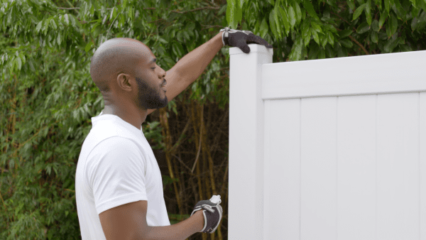 Vinyl Fence in a Box panel being installed in backyard